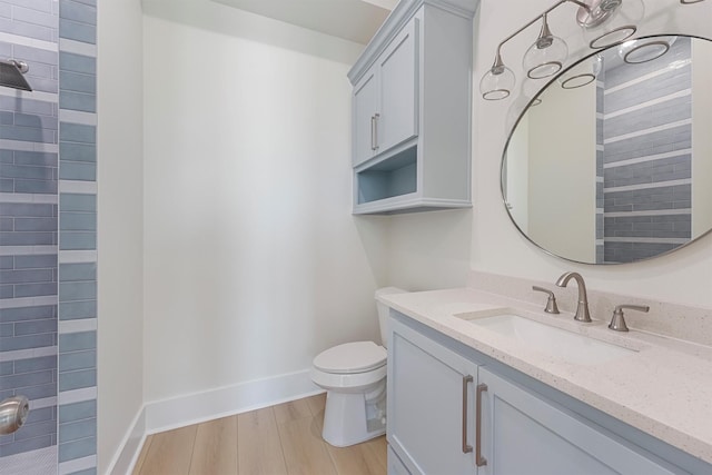 4042 Miramar Ct, Galveston, TX 77554 - bathroom featuring toilet, baseboards, wood finished floors, and vanity