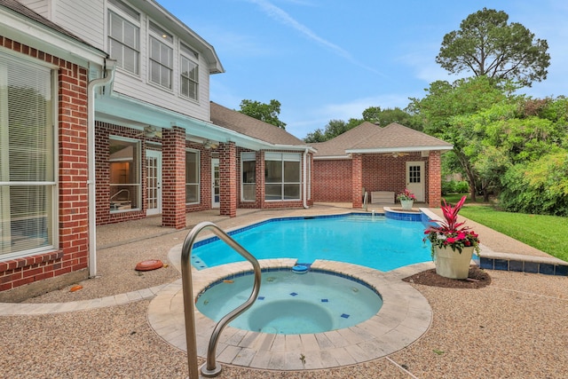 view of swimming pool featuring a ceiling fan, a patio area, and a pool with connected hot tub