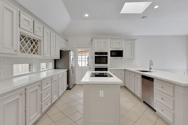 kitchen with a center island, tasteful backsplash, a sink, appliances with stainless steel finishes, and light tile patterned floors