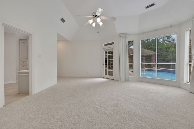 empty room featuring ceiling fan, light colored carpet, lofted ceiling, and visible vents