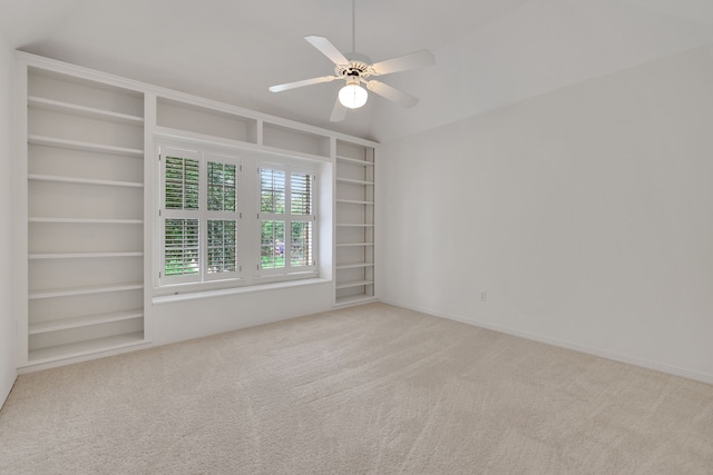 carpeted spare room with built in features and a ceiling fan
