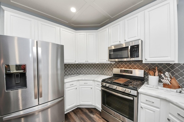 kitchen with appliances with stainless steel finishes, dark wood-style flooring, and white cabinetry