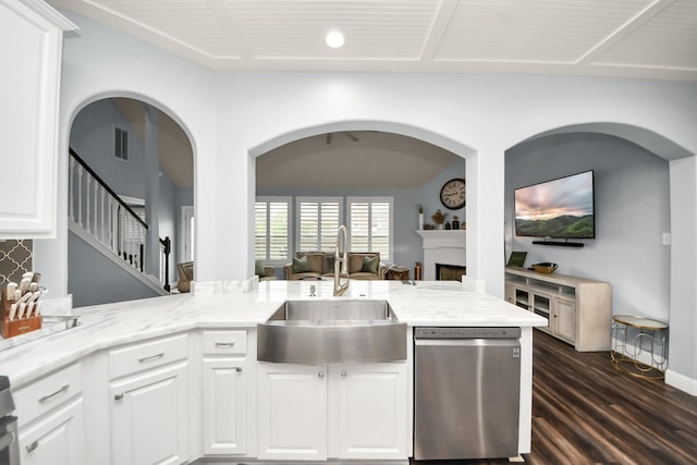 kitchen featuring visible vents, light stone countertops, dark wood-type flooring, a sink, and dishwasher