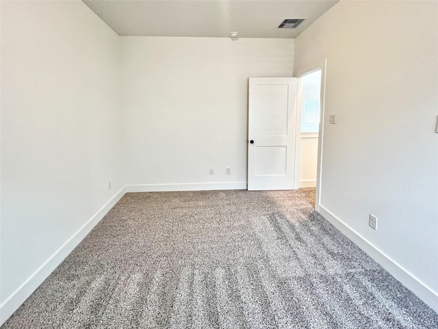 carpeted spare room with baseboards and visible vents