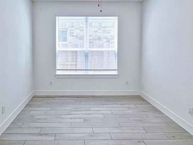 empty room featuring light wood-type flooring and baseboards