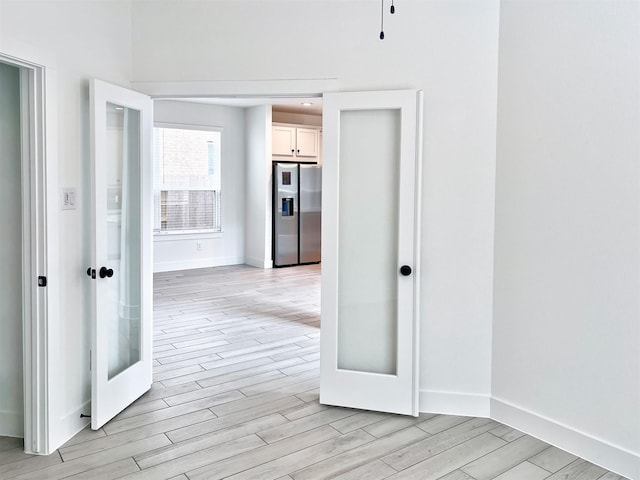 corridor featuring light wood-style floors and baseboards