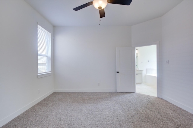 empty room featuring light colored carpet, baseboards, and ceiling fan