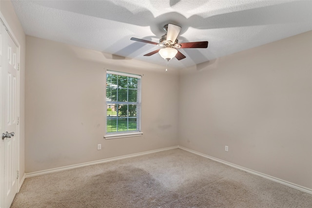 spare room featuring carpet floors, baseboards, and a ceiling fan