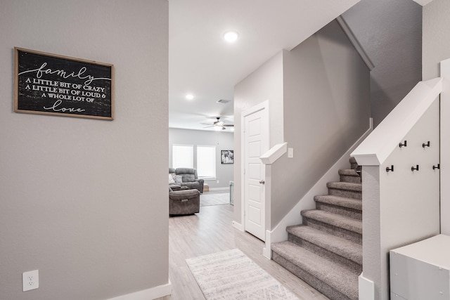 staircase with a ceiling fan, visible vents, wood finished floors, baseboards, and recessed lighting
