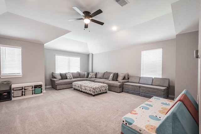 living area featuring a ceiling fan, visible vents, lofted ceiling, and carpet