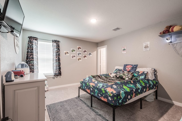 carpeted bedroom featuring baseboards and visible vents