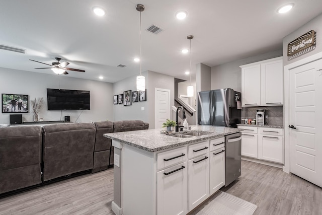 kitchen with stainless steel appliances, visible vents, a sink, and light wood-style flooring