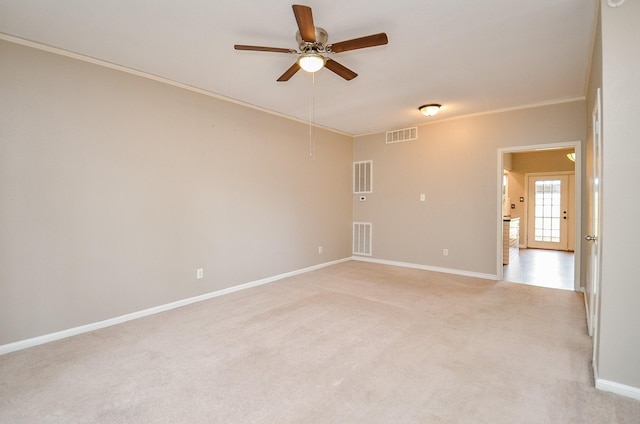 spare room with a ceiling fan, light colored carpet, and visible vents