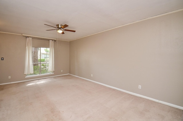 empty room featuring baseboards, ornamental molding, a ceiling fan, and light colored carpet