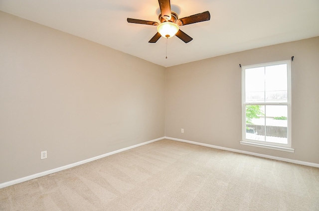 unfurnished room with baseboards, a wealth of natural light, a ceiling fan, and light colored carpet
