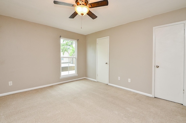 unfurnished room featuring baseboards, light carpet, and a ceiling fan