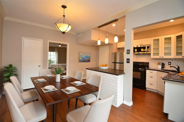 dining area featuring crown molding, dark wood-style flooring, and visible vents