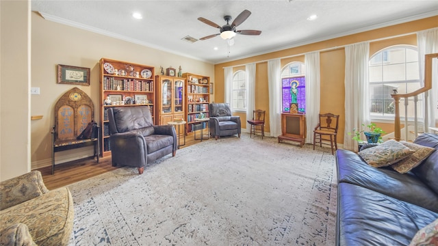 sitting room featuring crown molding, a ceiling fan, visible vents, and a wealth of natural light