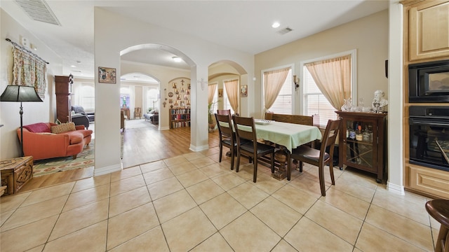 dining room with a healthy amount of sunlight, arched walkways, and visible vents