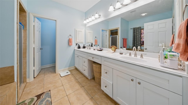 full bathroom featuring double vanity, tile patterned floors, a shower stall, and a sink