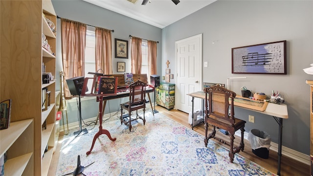 office space with baseboards, a ceiling fan, and wood finished floors