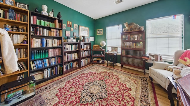 living area featuring visible vents, wood finished floors, and a wealth of natural light