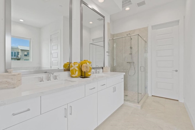 bathroom featuring visible vents, double vanity, marble finish floor, a sink, and a stall shower