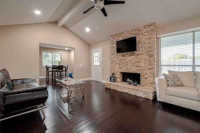 living area featuring ceiling fan, a fireplace, dark wood finished floors, baseboards, and vaulted ceiling with beams