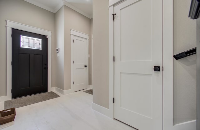 tiled foyer entrance with baseboards and ornamental molding