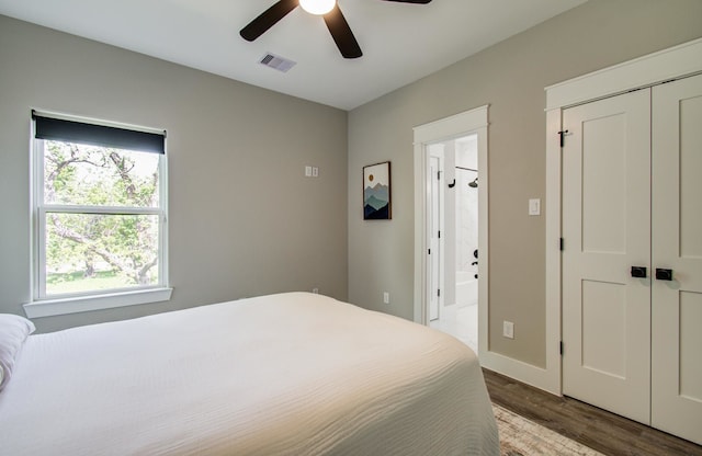 bedroom with ceiling fan, visible vents, wood finished floors, baseboards, and connected bathroom