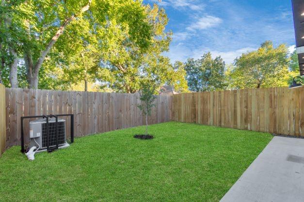 view of yard with central air condition unit and a fenced backyard