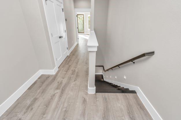 stairway with baseboards and wood finished floors