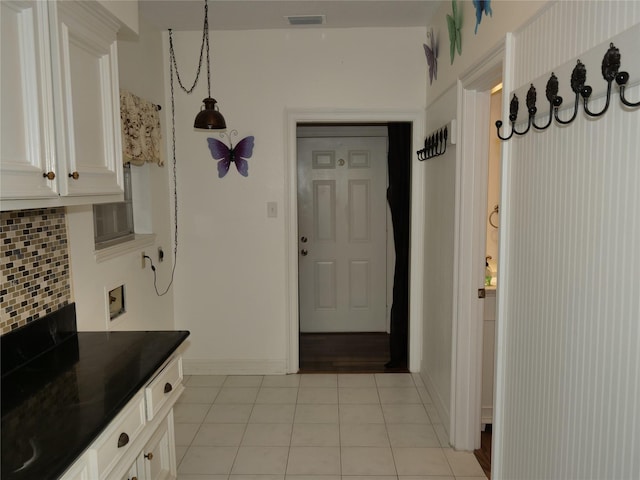 4202 Astwood Ct, Houston, TX 77068 - kitchen featuring white cabinets, light tile patterned flooring, dark countertops, tasteful backsplash, and visible vents