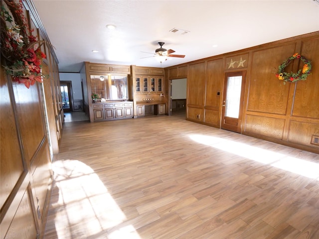 4202 Astwood Ct, Houston, TX 77068 - unfurnished living room featuring ceiling fan, visible vents, wooden walls, light wood-style floors, and ornamental molding