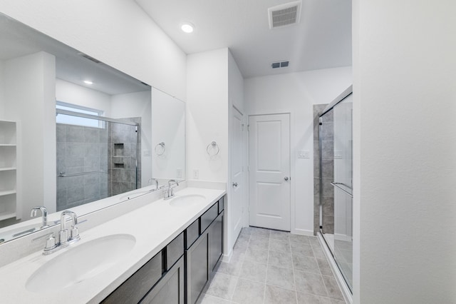 bathroom featuring visible vents, a sink, and a stall shower