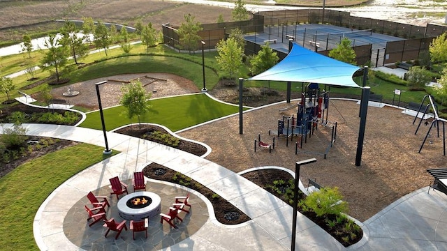 surrounding community featuring a yard, fence, playground community, and an outdoor fire pit