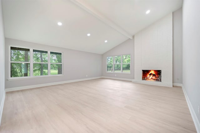 unfurnished living room featuring a brick fireplace, beamed ceiling, baseboards, and light wood finished floors