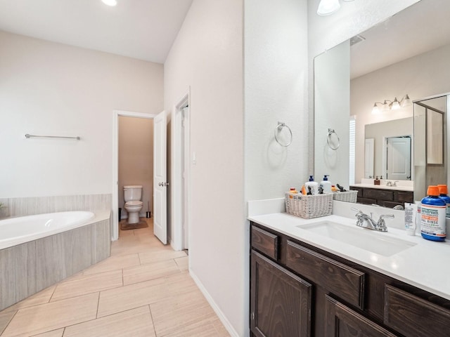 bathroom with vanity, a garden tub, and toilet