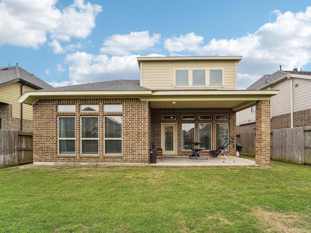 rear view of property with a fenced backyard, a patio, a lawn, and brick siding