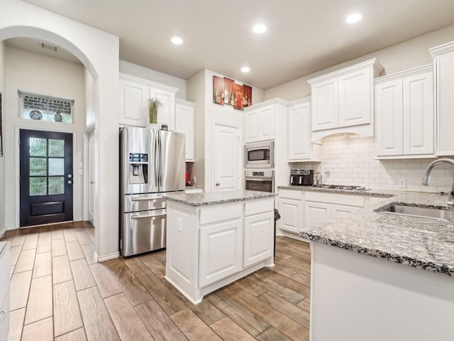 kitchen featuring visible vents, white cabinetry, a sink, light wood-style flooring, and appliances with stainless steel finishes