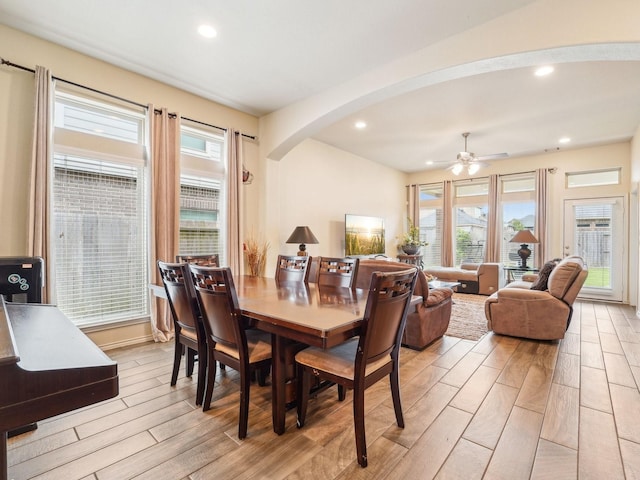 dining space featuring light wood-style floors, arched walkways, ceiling fan, and recessed lighting