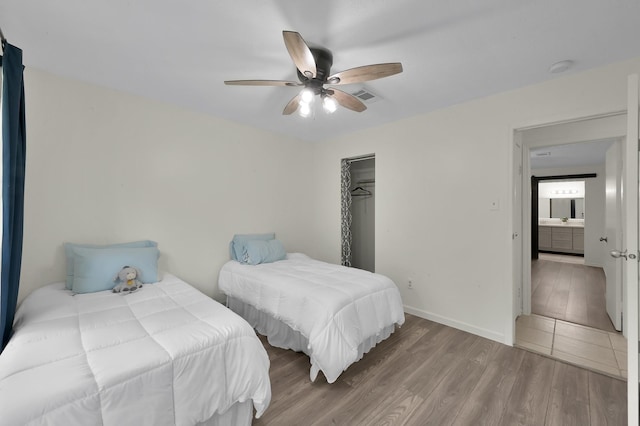 bedroom featuring baseboards, ceiling fan, visible vents, and wood finished floors