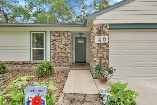 entrance to property featuring brick siding and an attached garage