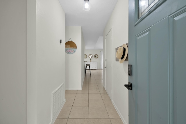 corridor with light tile patterned floors, baseboards, and visible vents