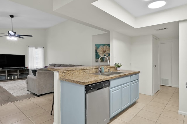 kitchen with light tile patterned flooring, open floor plan, light countertops, a sink, and dishwasher