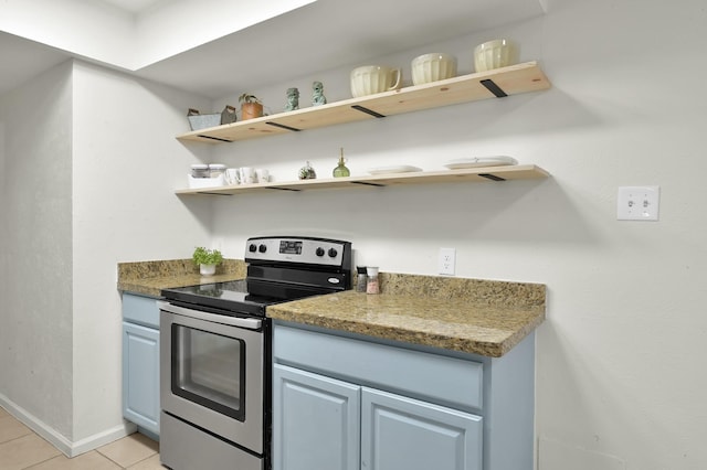 kitchen with blue cabinetry, open shelves, stainless steel electric range, light tile patterned floors, and baseboards