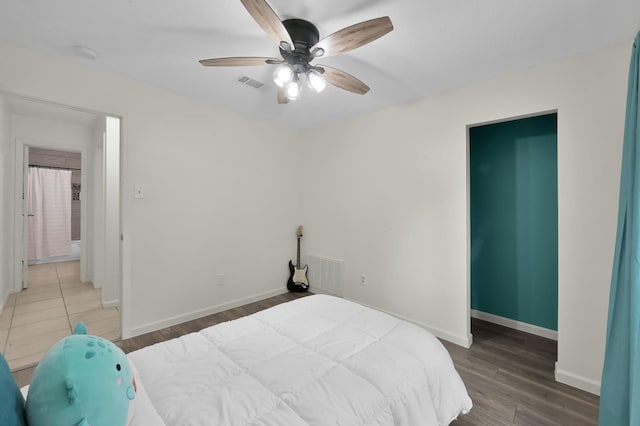 bedroom with baseboards, wood finished floors, and visible vents