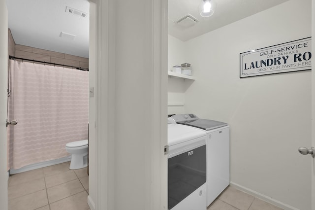 laundry area featuring laundry area, independent washer and dryer, light tile patterned floors, and visible vents