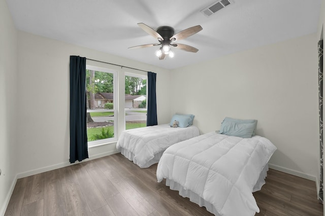 bedroom featuring baseboards, visible vents, and wood finished floors