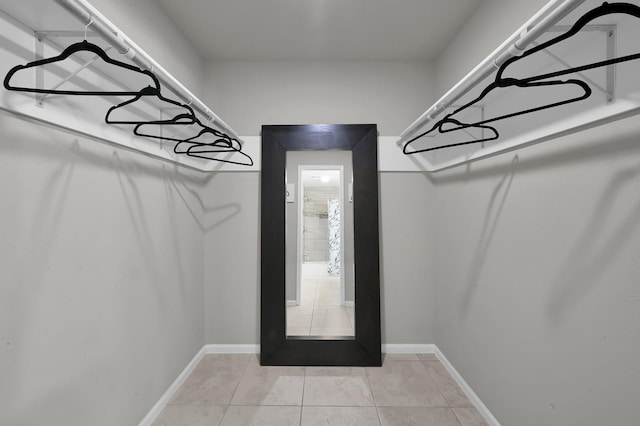 walk in closet with light tile patterned floors